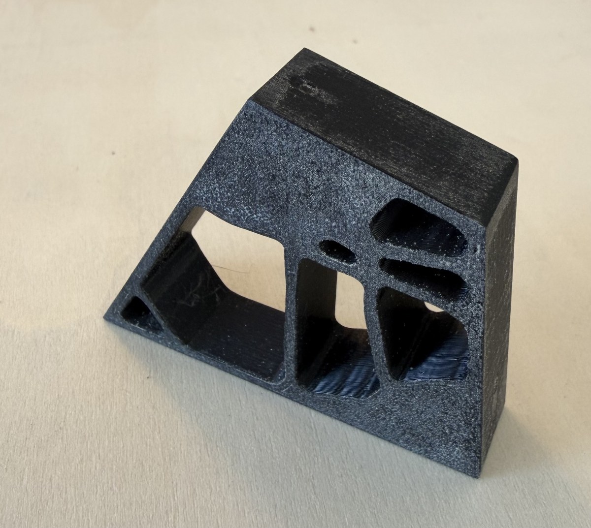 The bone bracket printed at one-third scale in dark filament