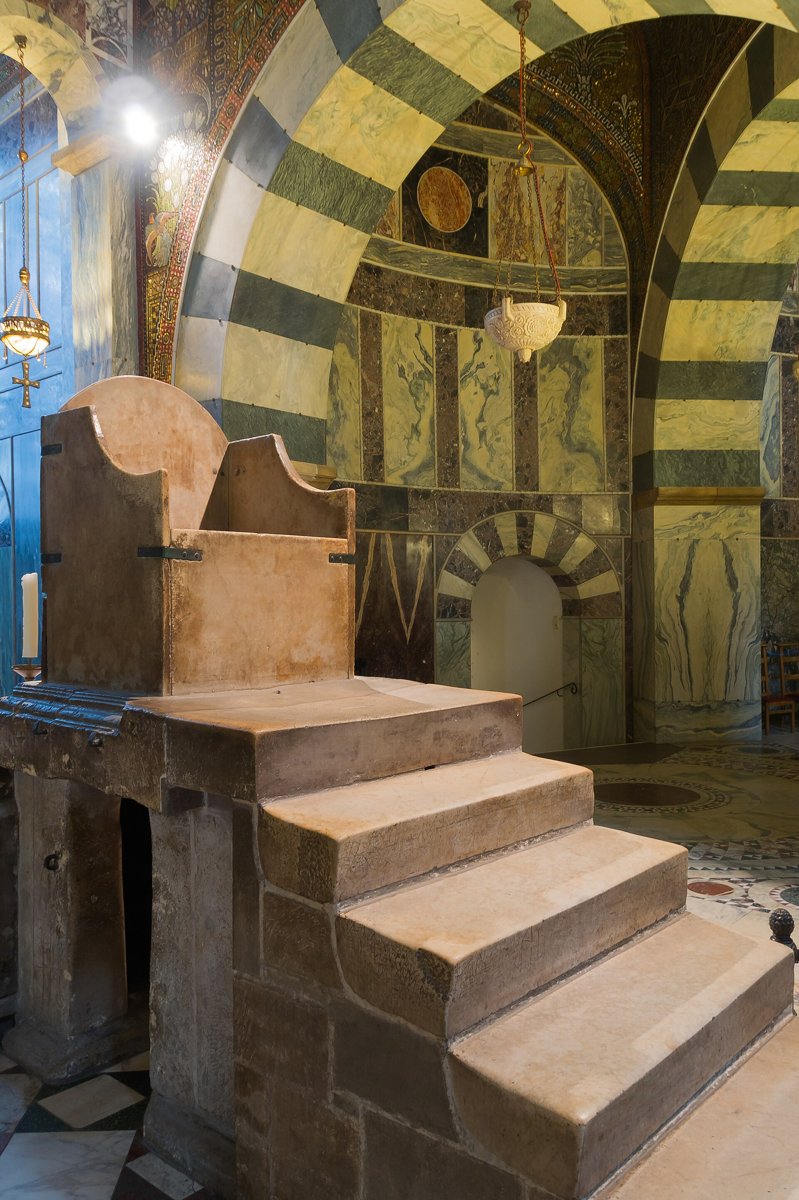 The throne of Charlemagne, 790s, in place in the Palatine Chapel, Aachen. Photo: Jebulon, CC0.