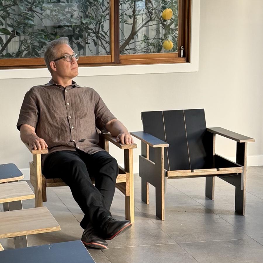Karl Ulrich seated in the camphor laurel Krat lounge chair, surrounded by other chairs from the project