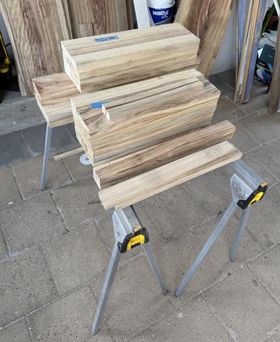 Milled camphor laurel hardwood on the sawhorses, the next chair still inside it.