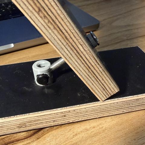 The barrel nut holder set into a plywood member.