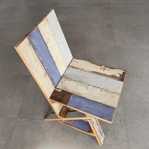 The cleat chair assembled from painted salvage boards: glued blocks, screwed joints, no glue in the final assembly.