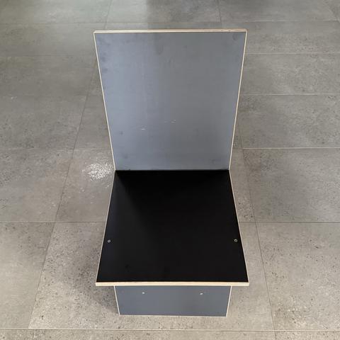 Straight-on front view of the keel chair, gray back panel above black seat