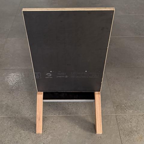 Rear view of the keel chair, structural plywood grade stamp visible on the back panel, two hardwood keel feet below