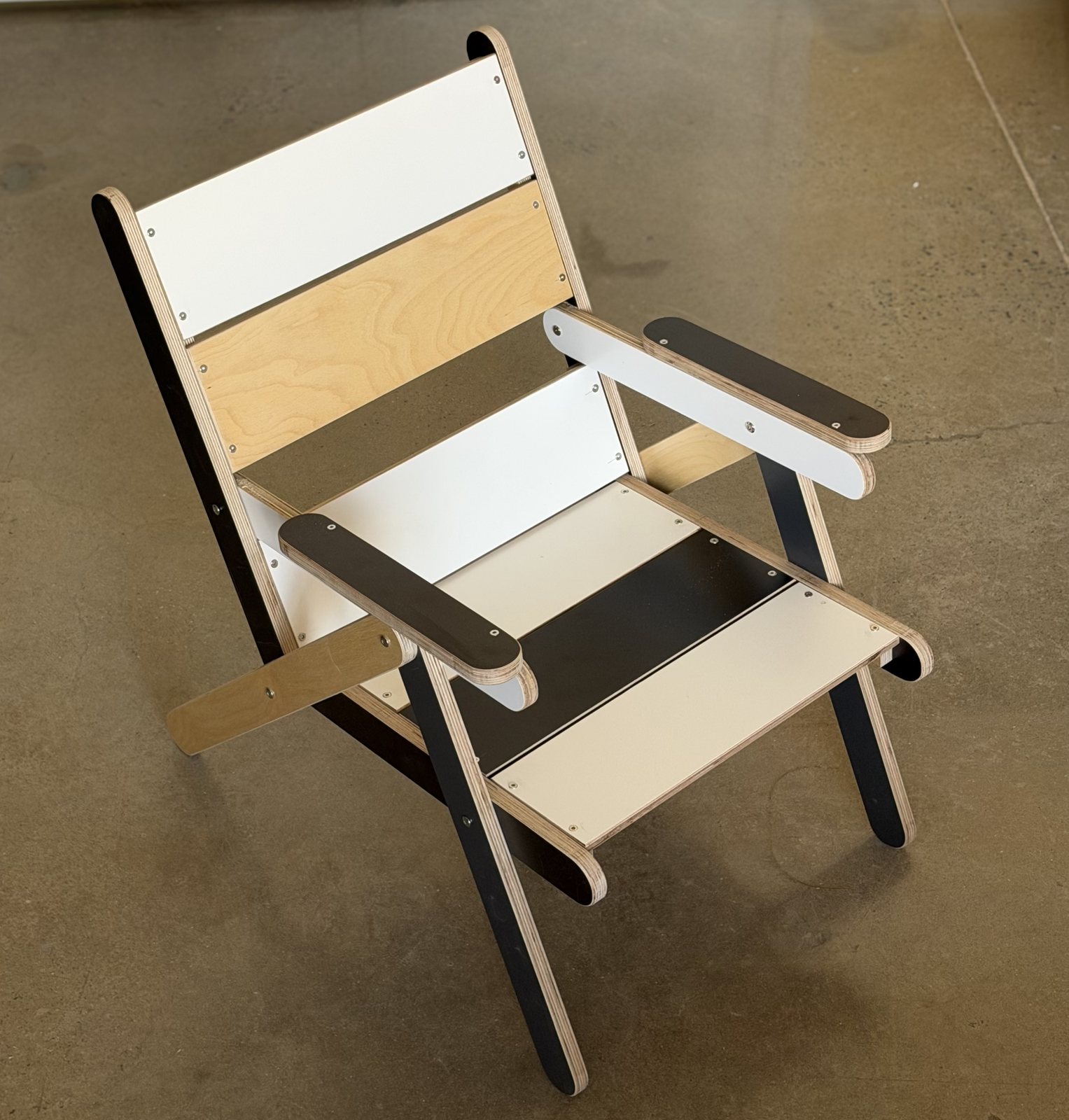 The third K3 from the front quarter: white and black film-faced sticks with birch edges, a birch keel, recessed panels in two finishes, the stainless screw line along each panel edge.